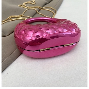 Detail of heart-shaped mini bag with fuchsia quilted finish and gold chain strap