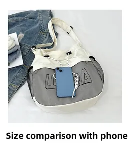 Close-up of canvas drawstring tote with LIRA logo next to a smartphone for size reference