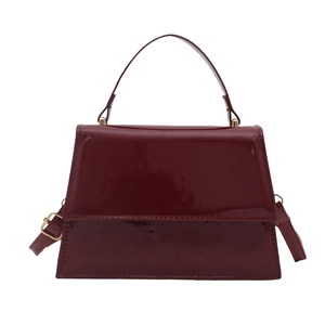 Glossy deep red leather handbag in trapezoid shape with gold hardware for commuting