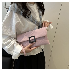 Detail of pink faux suede envelope clutch bag featuring a large black square buckle and strap