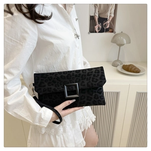 Detail of black leopard print clutch bag with a square buckle and wristlet strap