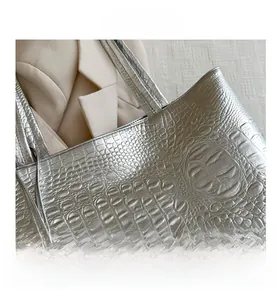 Détail du sac cabas argenté avec texture crocodile gaufrée et finition métallisée