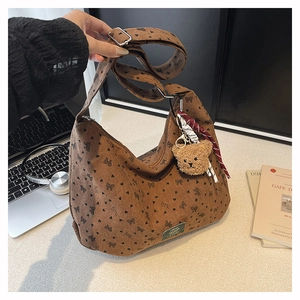 Détail du sac cabas en velours côtelé marron avec motifs cœurs et porte-clés ours