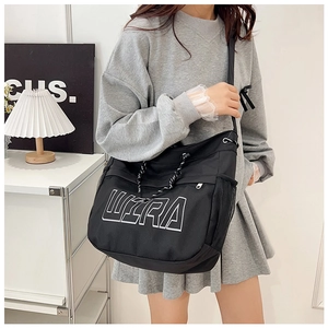Detail of black large-capacity tote bag featuring white ULTRA text and mesh side pocket