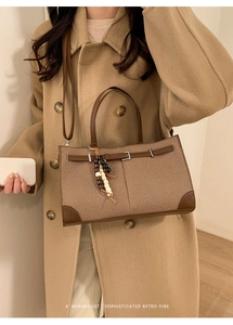 Close-up of retro woven tote bag with brown leather handles and wooden bead tassel