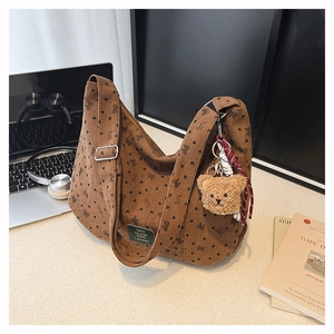 Détail du sac cabas en velours marron avec motifs de cœurs et porte-clés ours peluche