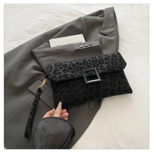 Detail of black leopard print clutch with velvet texture and square metal buckle