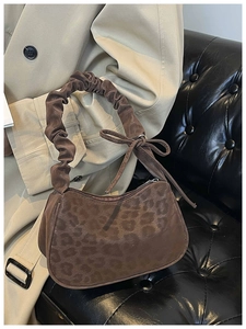Detail of leopard print faux suede shoulder bag with pleated handle and side bow