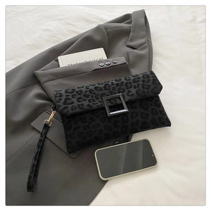 Detail of leopard print clutch bag with black square buckle and matching wrist strap