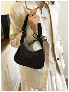 Dettaglio della borsa leopardata con manico arricciato e fiocco decorativo alla moda