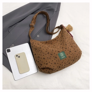 Détail d'un sac fourre-tout en velours côtelé marron avec motifs cœurs et ours en peluche