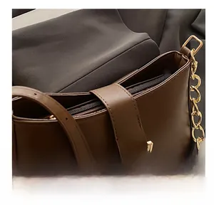 Vue détaillée du sac à main en cuir marron foncé avec boucle dorée et coutures de précision