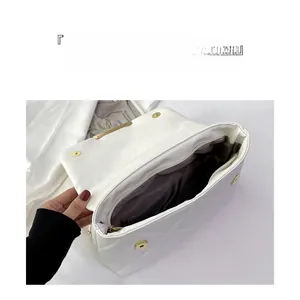 Detailed interior view of white quilted bag showing large capacity and brown lining