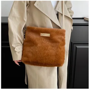 Détail du sac à bandoulière en peluche caramel avec plaque dorée et lanière en cuir