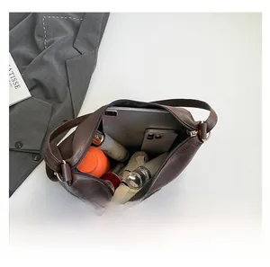Interno spazioso della borsa tote marrone scuro con oggetti e cerniera di sicurezza