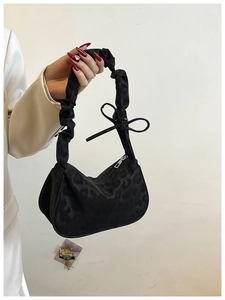 Detail of vintage leopard print bag with scrunchie handle and silver metal zipper