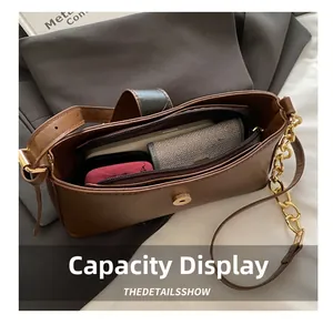 Vue intérieure du sac baguette marron montrant des compartiments et un fermoir aimanté