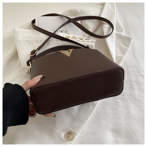 Detail showing the base thickness and texture of a dark brown lychee leather handbag
