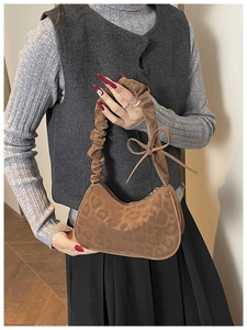 Dettaglio borsa leopardata con manico arricciato e decorazione a fiocco chic
