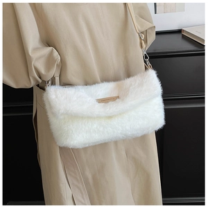 Détail du sac à bandoulière en peluche blanche avec étiquette en cuir brun et sangle beige