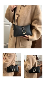 Détail du sac sous l'aisselle en cuir noir avec boucle magnétique dorée en forme de U