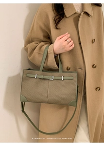 Detail of retro tote bag showing woven texture, green leather trim and metal clasp
