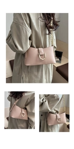 Détail du sac sous le bras en cuir rose nude avec boucle en U dorée et bandoulière