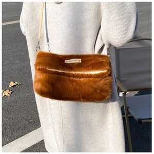 Détail du sac en peluche marron avec étiquette de marque et texture en fausse fourrure