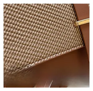Detail showing brown leather stitching and textured woven fabric with a gold buckle