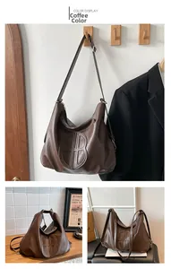 Dettaglio borsa hobo marrone caffè con lettera B goffrata e tracolla regolabile morbida