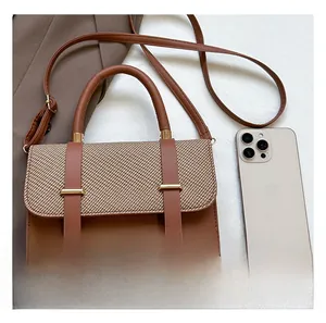 Detailed comparison of brown woven crossbody bag size with a modern smartphone