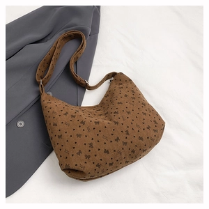 Détail du sac fourre-tout en velours côtelé caramel avec motifs de cœurs et nœuds noirs