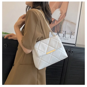 Detailed shot of white quilted chain bag with gold metal buckle and woven strap