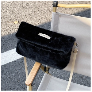 Détail de la texture en fausse fourrure noire avec logo TIANYUNYICAI et bandoulière beige