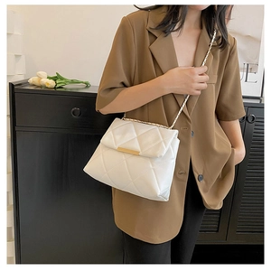 Detail of white quilted chain bag with gold metal trim and elegant diamond stitching