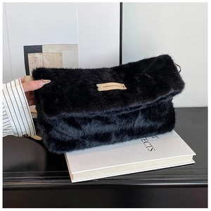 Détail du sac à main en fausse fourrure noire douce avec étiquette logo en cuir