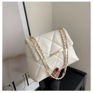Close-up of white quilted leather chain bag with elegant gold metallic accents