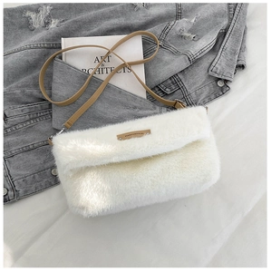 Détail du sac à bandoulière en fausse fourrure blanche douce avec étiquette en cuir
