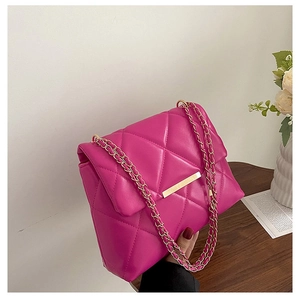 Detailed view of quilted rose red flap bag with gold chain strap and metal clasp