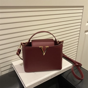 Chic burgundy lychee grain handbag with gold V-hardware and versatile crossbody strap