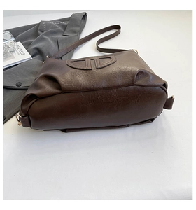Dettaglio della borsa tote marrone in finta pelle con logo in rilievo 3D e grana litchi