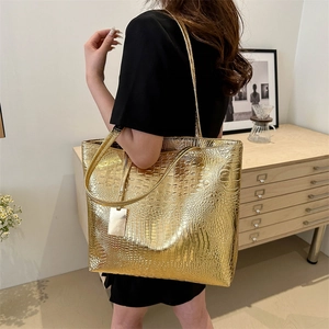 Grand sac cabas doré avec motif crocodile présenté dans un intérieur élégant