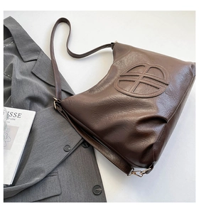 Dettaglio della borsa tote vintage marrone scuro con motivo circolare in rilievo e tracolla