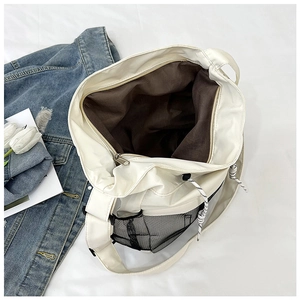 Detail view of large tote bag with dark brown lining, mesh pocket and drawstring closure
