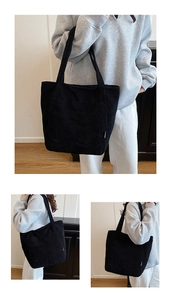 Detail of black corduroy tote bag showing side label and large capacity for commuting