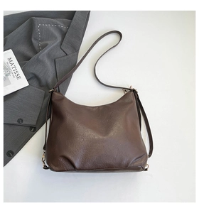 Dettaglio della borsa tote in pelle marrone scuro con trama a grana e tracolla regolabile