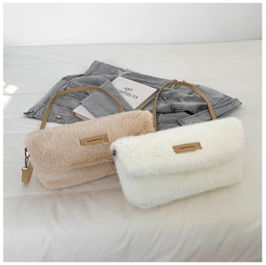 Détail de sacs bandoulière en peluche beige et blanc avec logo et bandoulière en cuir