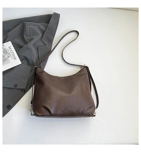 Dettaglio di una borsa tote marrone in pelle PU con motivo lychee, fibbia metallica e tracolla