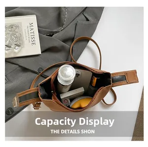 Top view of brown leather bag showing large capacity with phone, makeup and water bottle