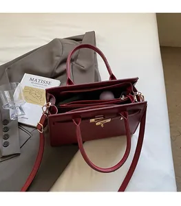 Detail of red textured leather tote bag interior featuring gold clasp and compartments